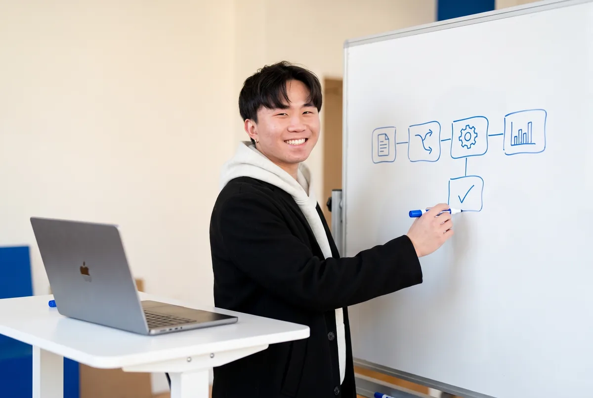 Ray Fu drawing an automation workflow on a whiteboard
